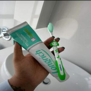 a man holding longrich non floruide white tea toothpaste with longrich toothbrush