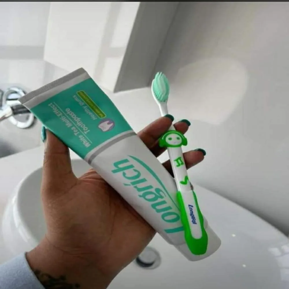 a man holding longrich non floruide white tea toothpaste with longrich toothbrush